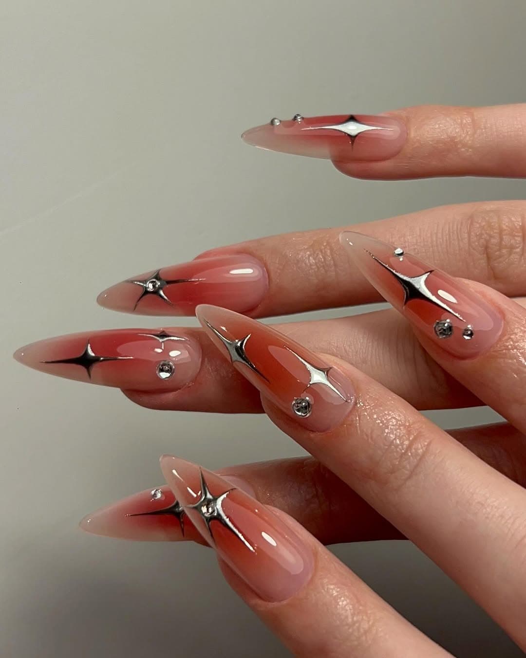 Nail art signature Hotspicynailz : aura cerise et étoiles chrome, pose Gel-X à Lyon